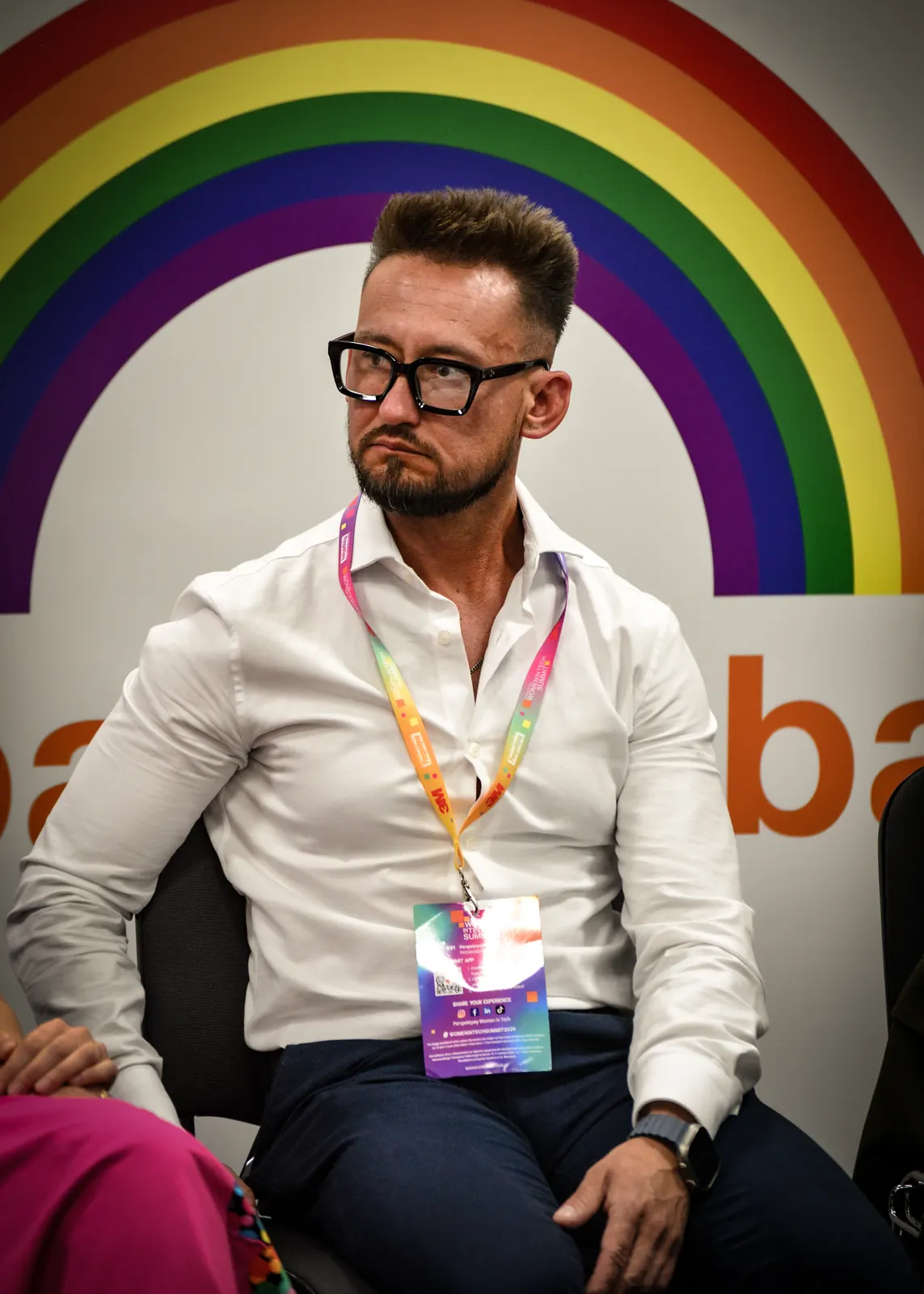 Jorge seated on the panel, listening to another speaker